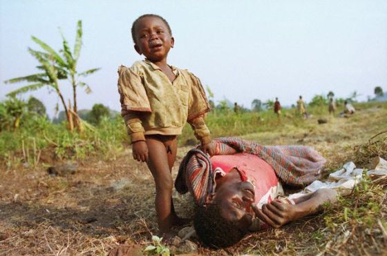 1994, Goma, Zaire --- A young Rwandan boy cries and clings to his dead father, who died moments before of cholera. The two had fled the Hutu-Tutsi violence in Rwanda and come to Zaire for safety. --- Image by © David Turnley/CORBIS
